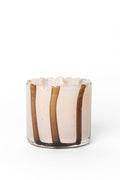 A small clear glass candle holder with a scalloped rim, featuring vertical amber-brown glass stripes on a translucent pale pinkish-tinted glass body, set against a plain white background.