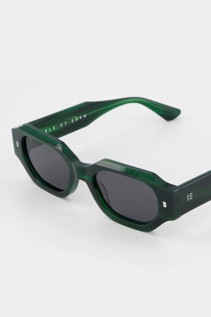 Green sunglasses with dark lenses on a white background