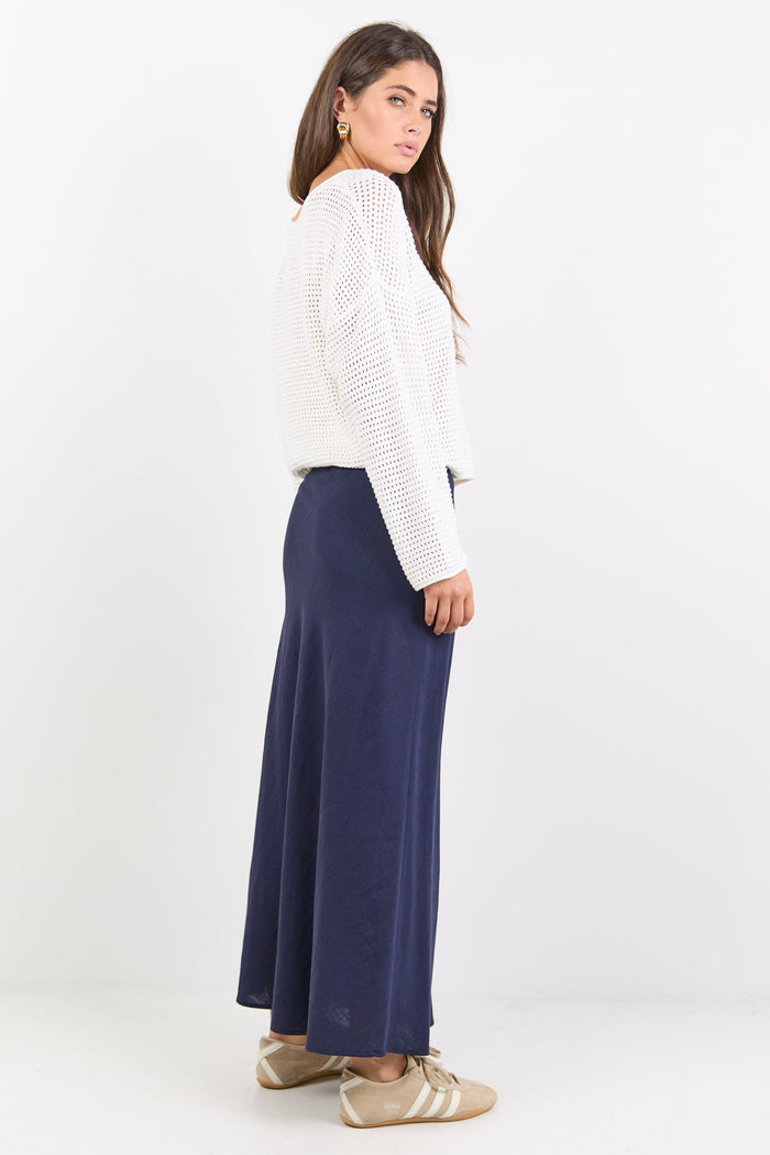 Woman wearing a white blouse and navy skirt on a white background