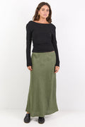 Woman wearing a black top and green skirt on a white background
