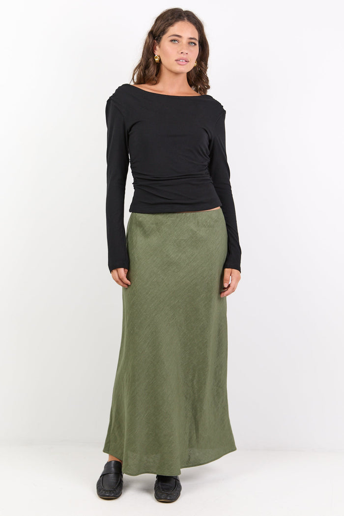 Woman wearing a black top and green skirt on a white background