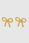 A pair of delicate gold-toned stud earrings shaped like bows, crafted from small polished metal beads arranged in a symmetrical design