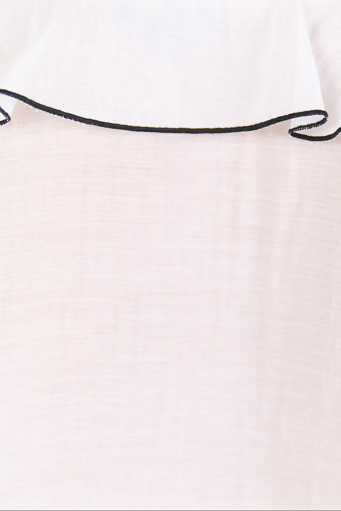 Close-up of a white top with black trim