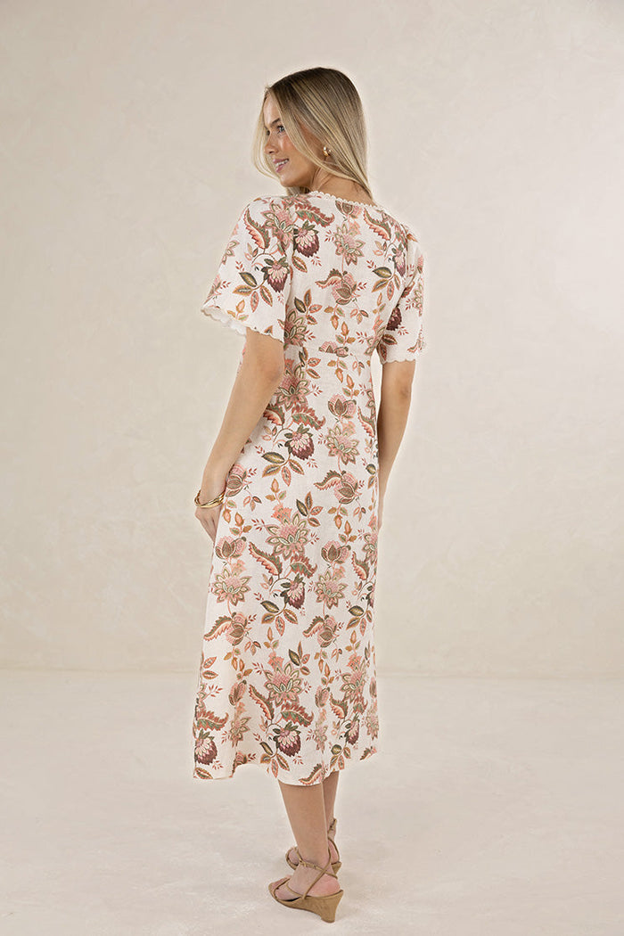 Woman wearing a floral dress on a plain background