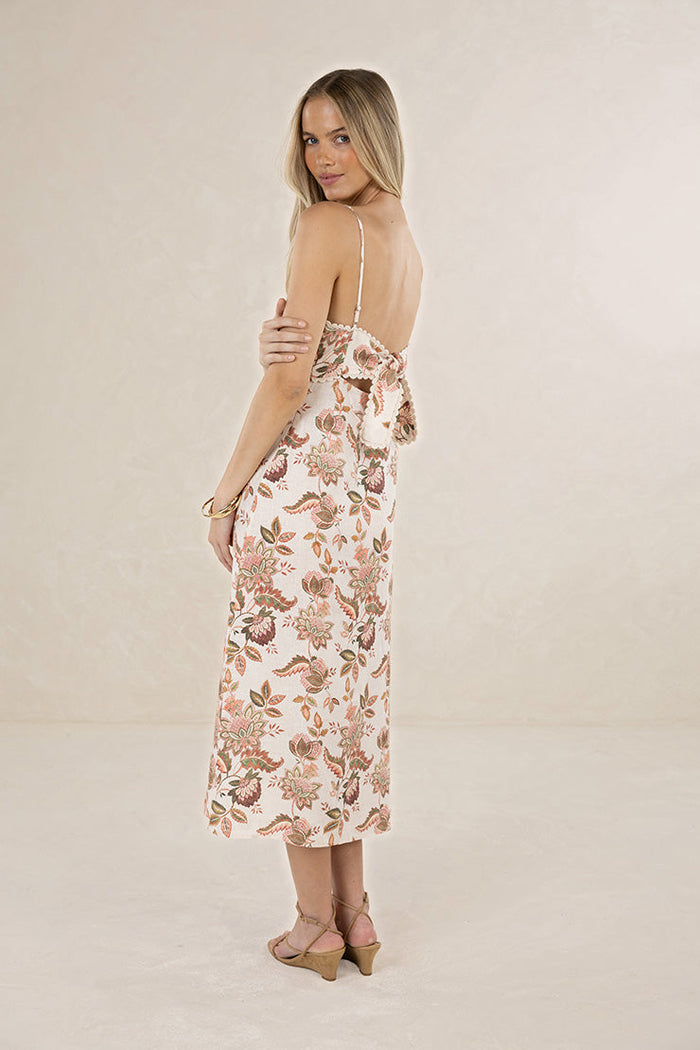 Woman wearing a floral dress on a plain background