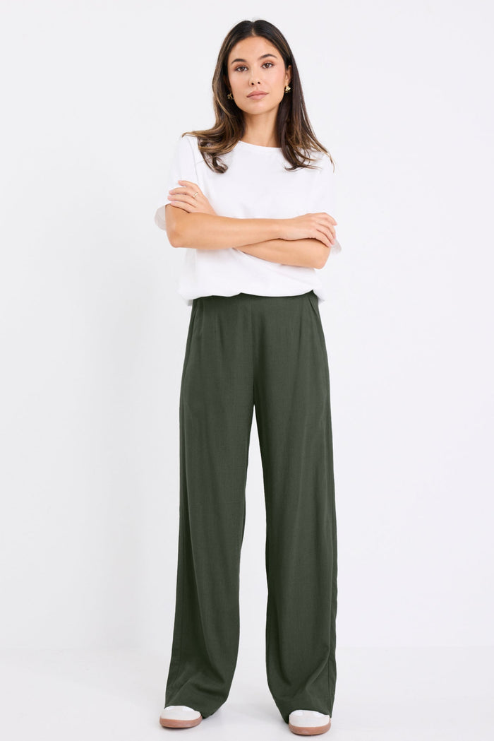model wears a khaki linen pant with a white t-shirt