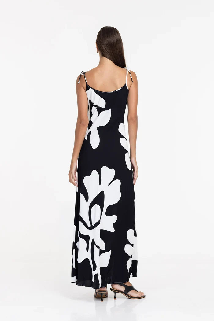 Woman wearing a black dress with white floral patterns on a white background