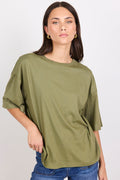 Woman wearing an olive green oversized t-shirt against a plain background