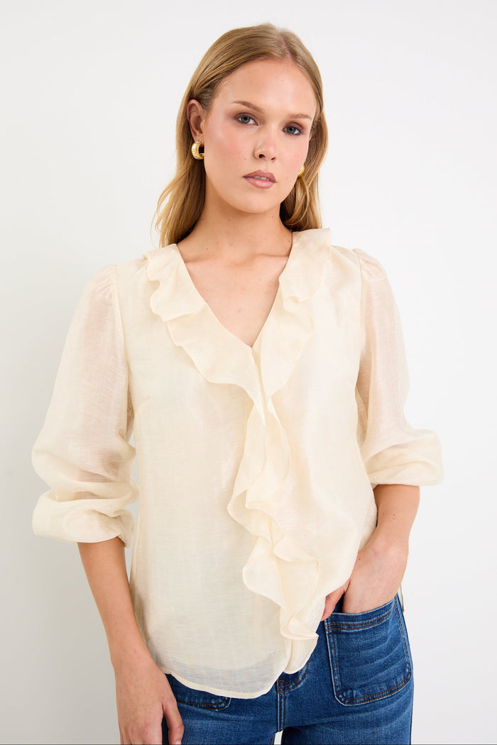 cream frill top and blue jeans