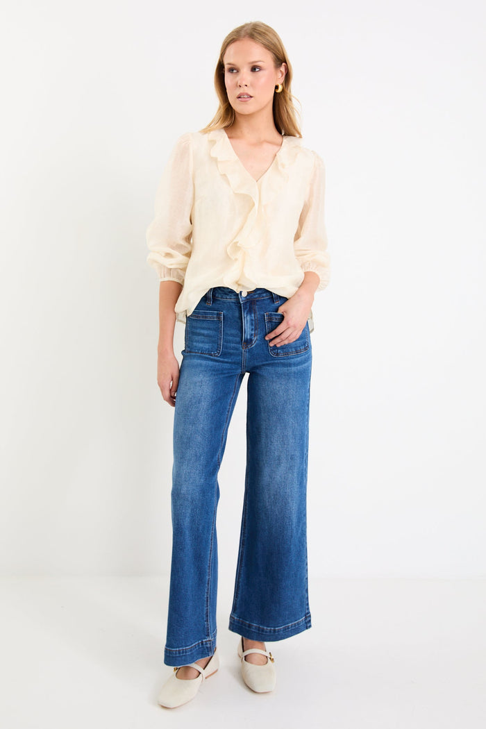 cream frill top and blue jeans
