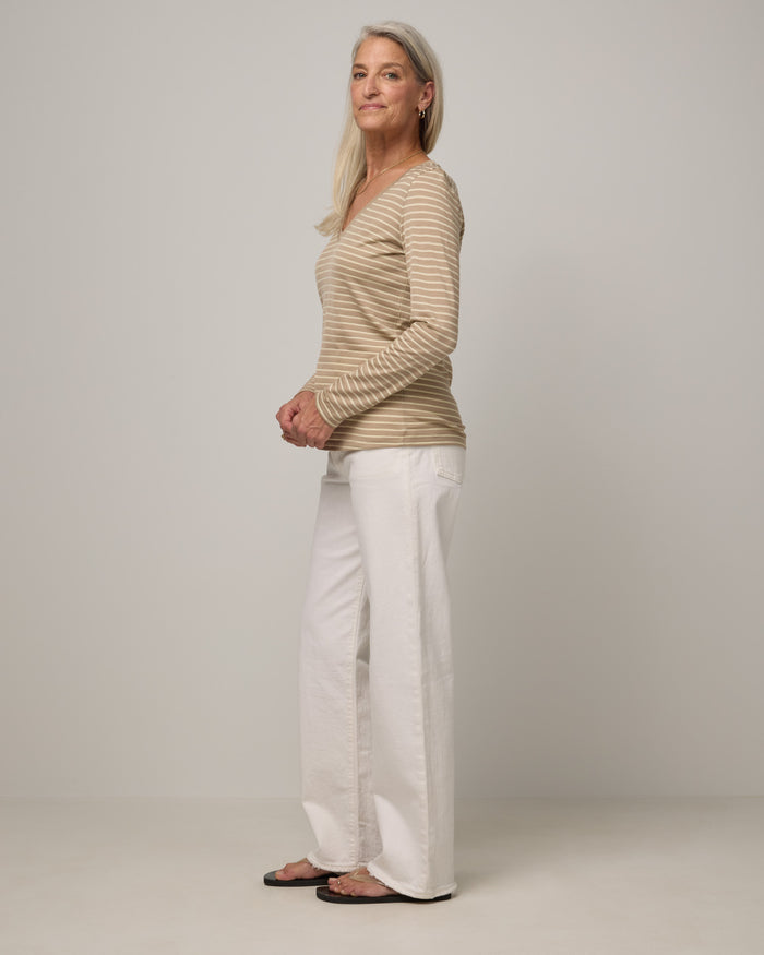 Model wearing Brenton V-Neck Tee in Khaki & Natural White Stripe. Brenton V-Neck Tee is a merino wool long sleeve, v-neck, regular fit tee available in sizes XS-3X.