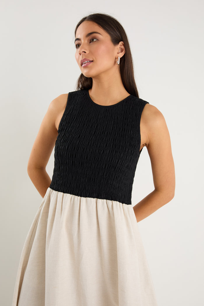 Woman wearing a black sleeveless top and beige skirt against a plain background
col_pattern