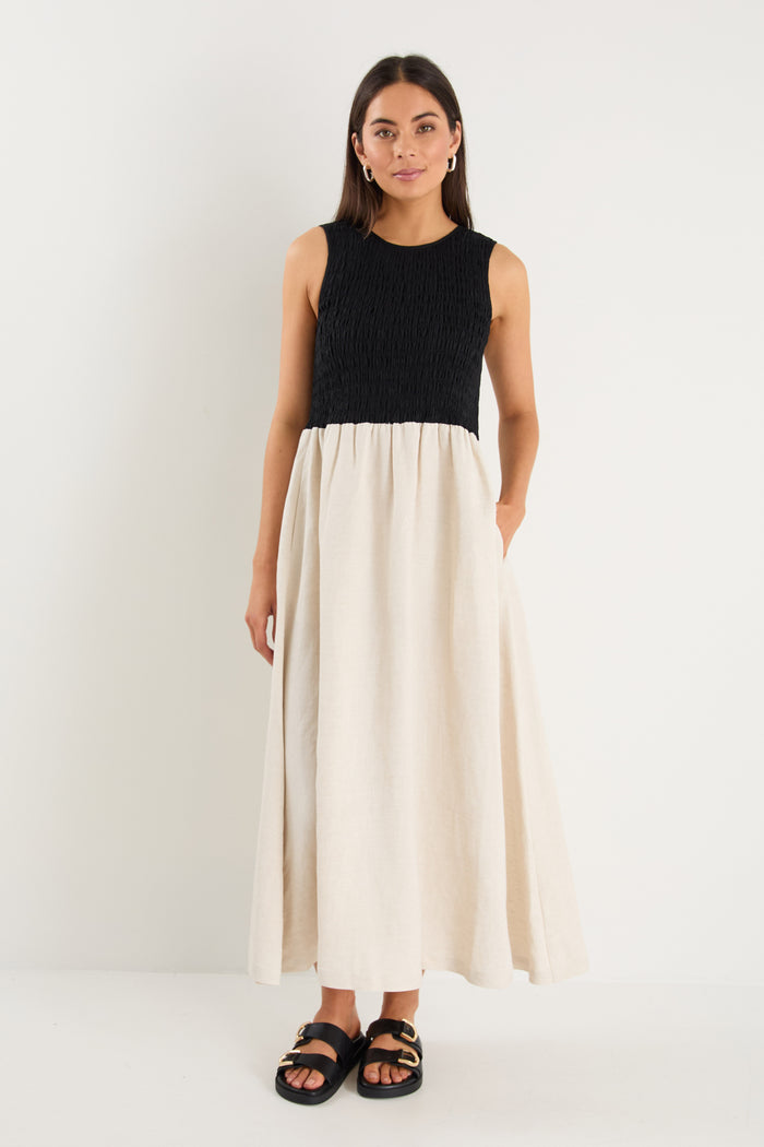 Woman wearing a black top and white skirt on a white background