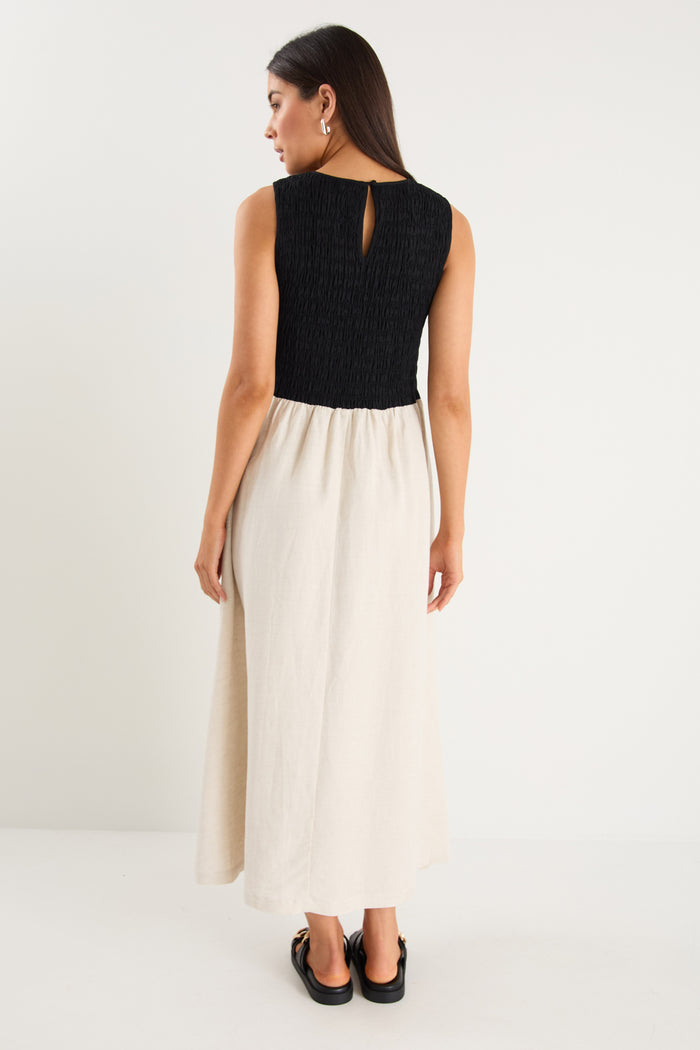 Woman wearing a black top and white skirt on a white background