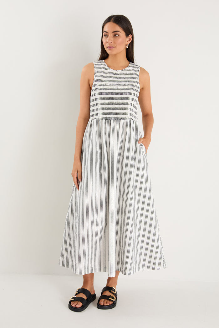 Woman wearing a black white striped dress and strappy black sandals
