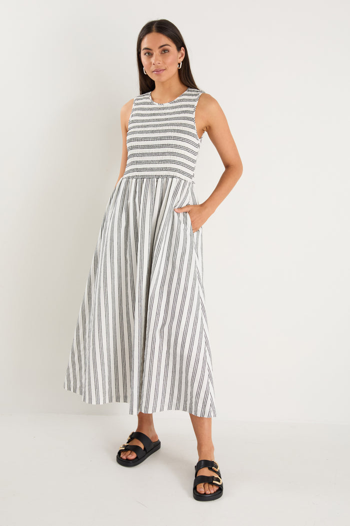 Woman wearing a black white striped dress and strappy black sandals