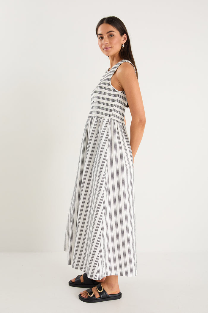 Woman wearing a black white striped dress and strappy black sandals