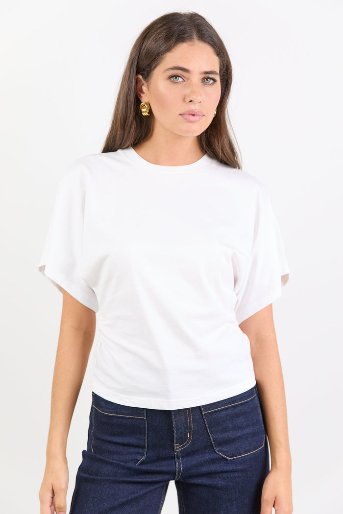 Woman wearing a white t-shirt and dark blue jeans on a white background