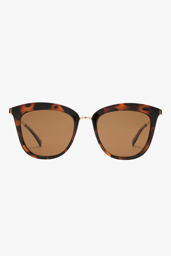 cat-eye sunglasses in a tortoiseshell frame with warm brown lenses. A slim gold-tone bridge and matching gold arms add a polished touch to the bold silhouette.
