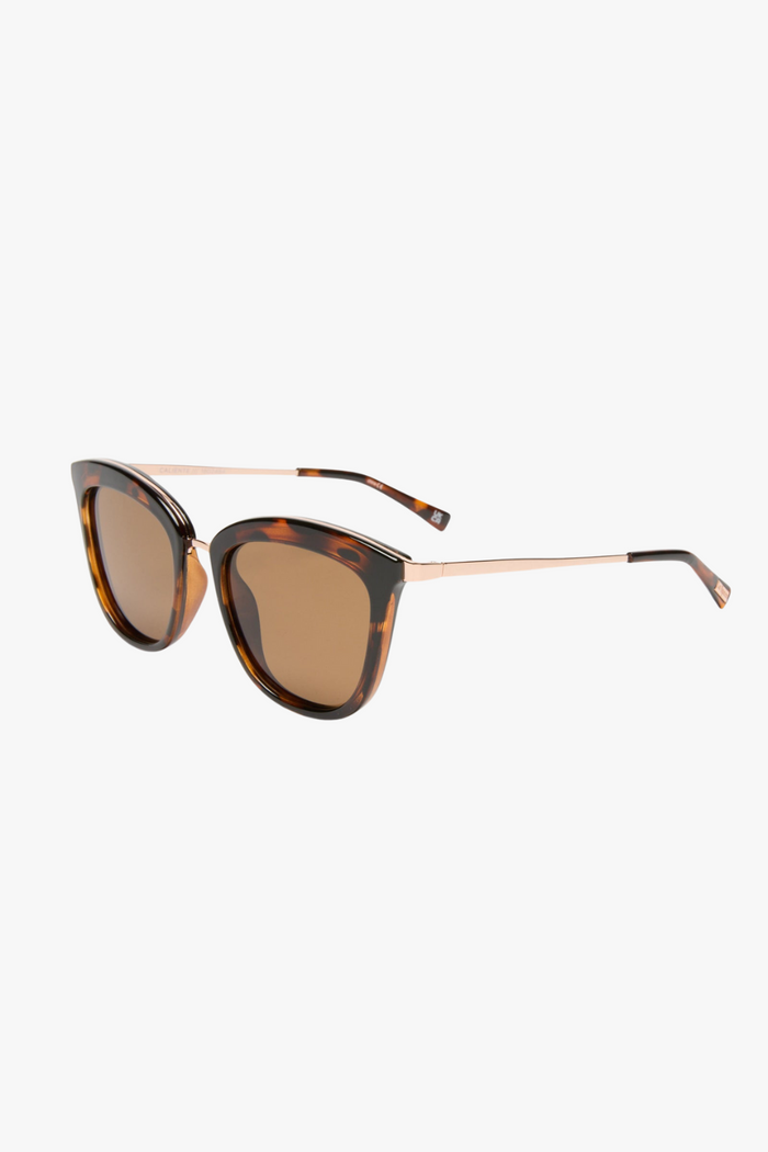 cat-eye sunglasses in a tortoiseshell frame with warm brown lenses. A slim gold-tone bridge and matching gold arms add a polished touch to the bold silhouette.