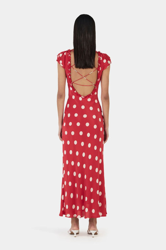Woman wearing a red polka dot dress with a white background