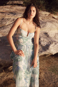Woman in a floral dress standing on rocky terrain