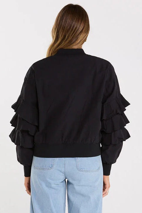 Person wearing a black shirt and light blue jeans on a white background
col_pattern