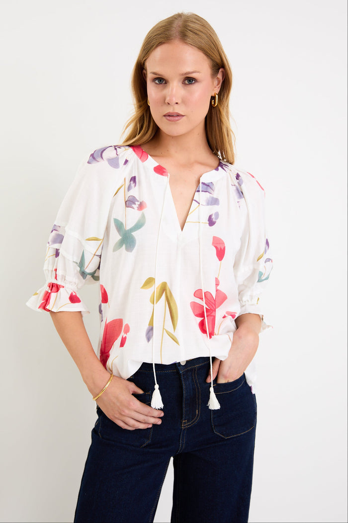 Woman wearing a cream floral poppy top and blue jeans
@col_pattern