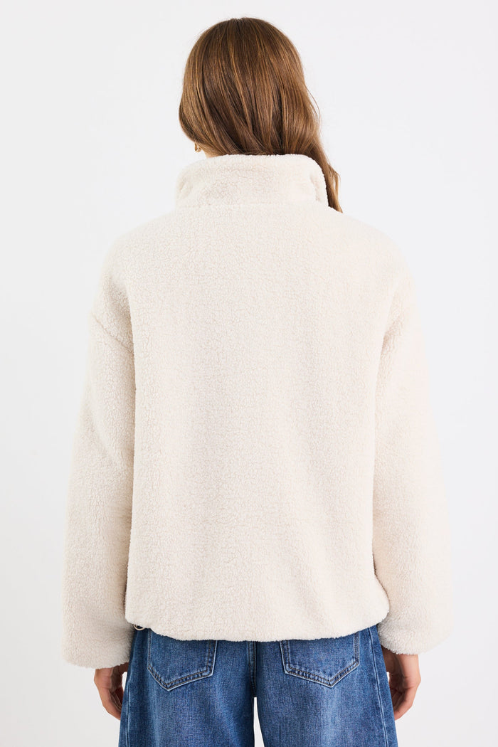 Person wearing a white jacket and blue jeans on a white background
col_pattern