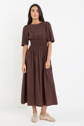 Woman wearing a brown dress on a white background