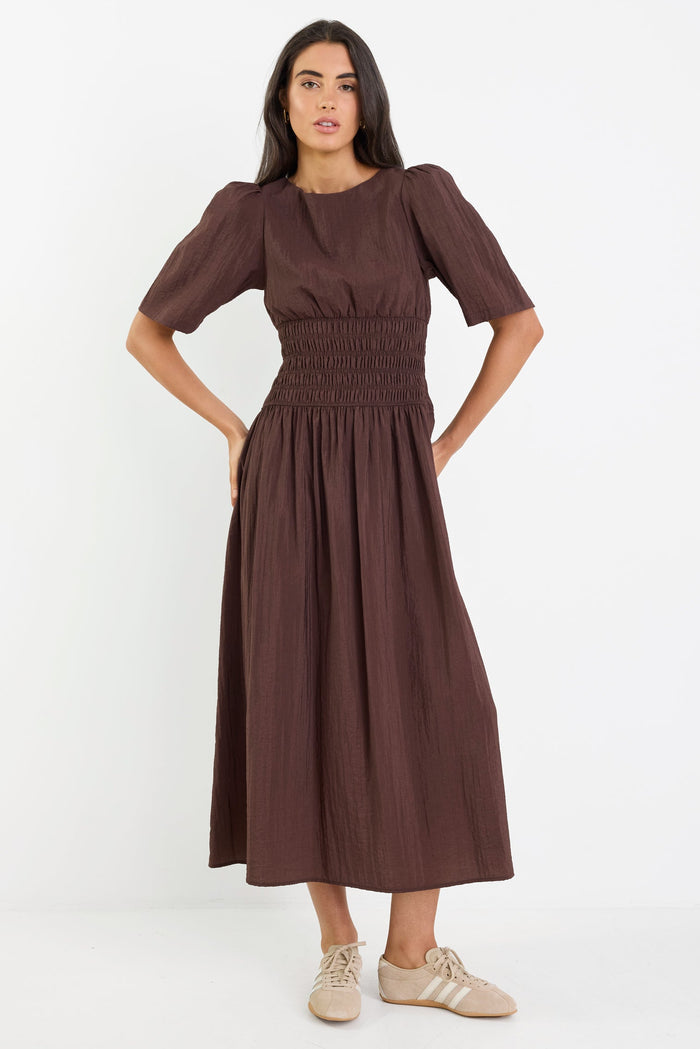 Woman wearing a brown dress on a white background