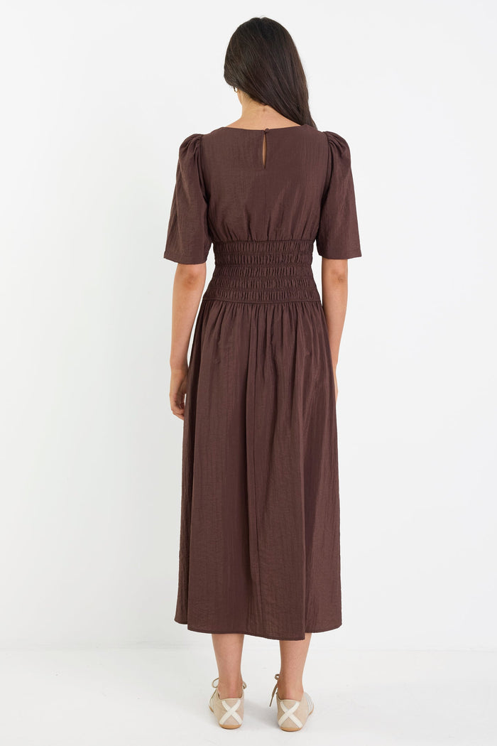 Woman wearing a brown dress on a white background