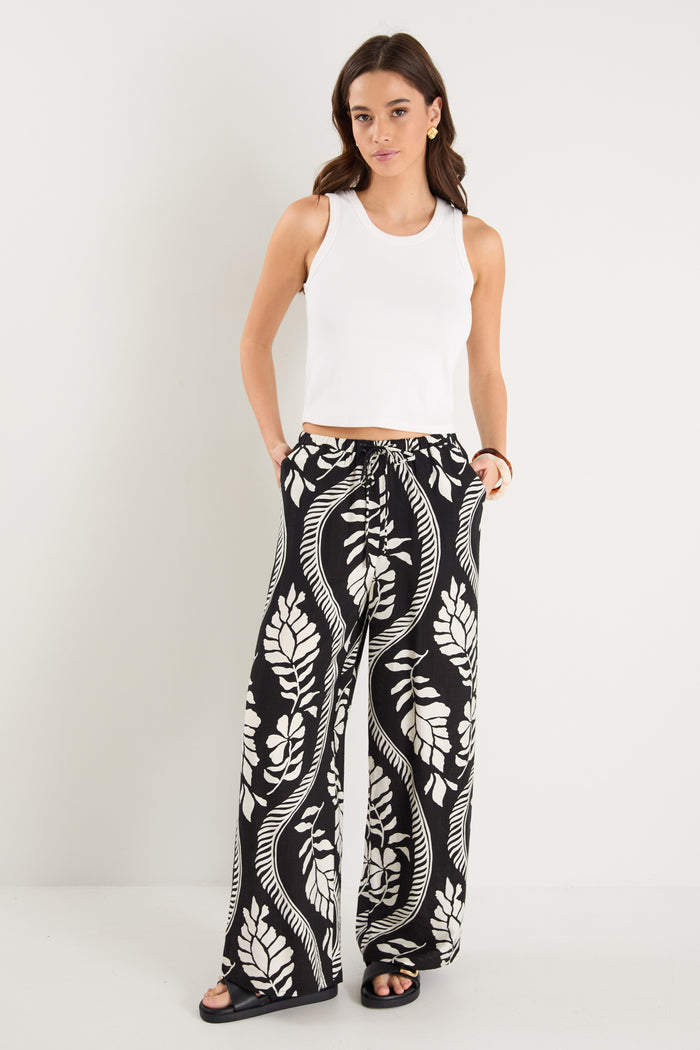 woman wearing black white pant and white top