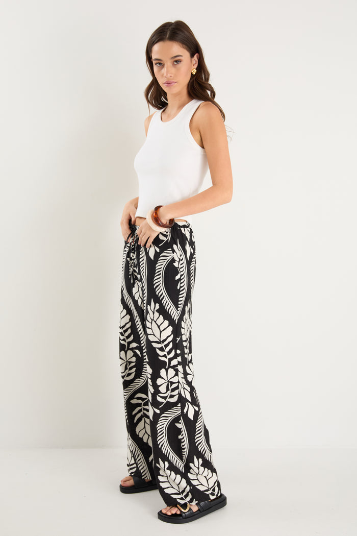 woman wearing black white pant and white top