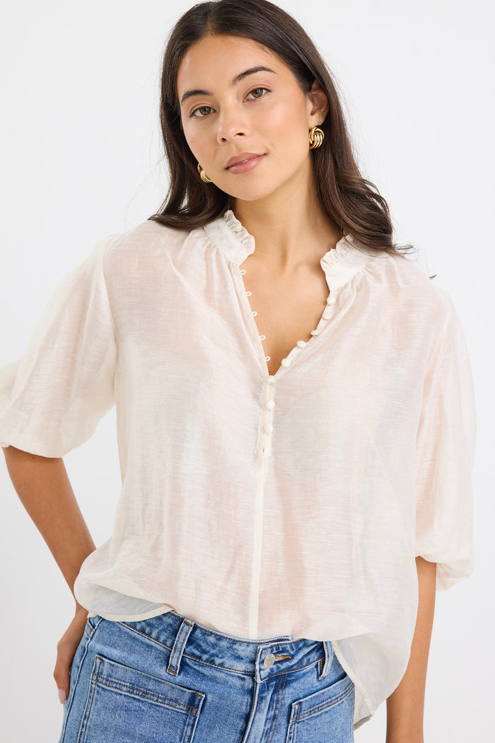 model wears a white blouse with light blue high waisted jeans