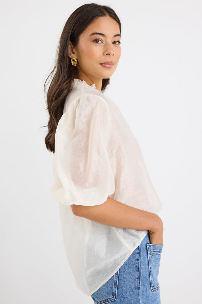 model wears a white blouse with light blue high waisted jeans