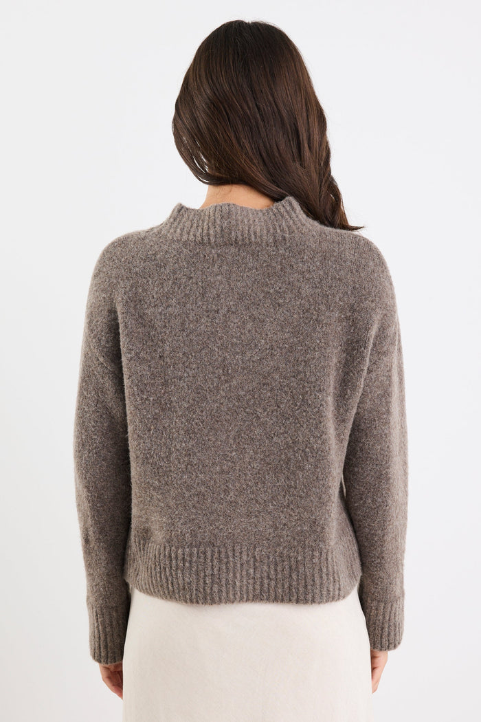 Person wearing a gray sweater on a white background