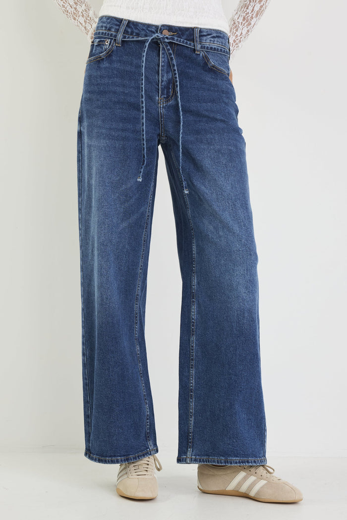 Blue jeans worn by a person on a white background