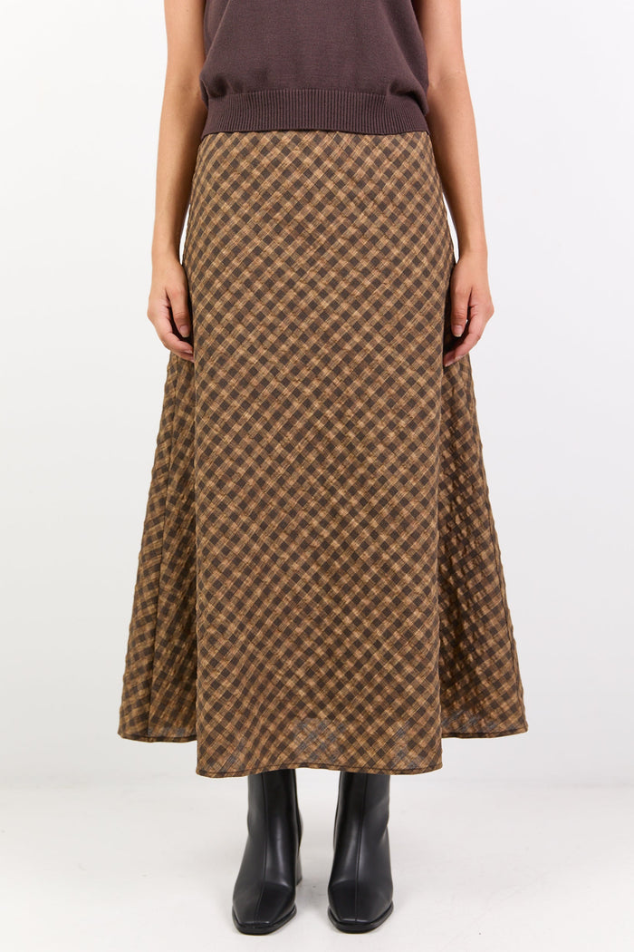 Person wearing a brown patterned skirt on a white background