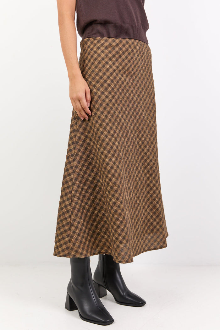 Person wearing a brown checkered skirt on a white background
