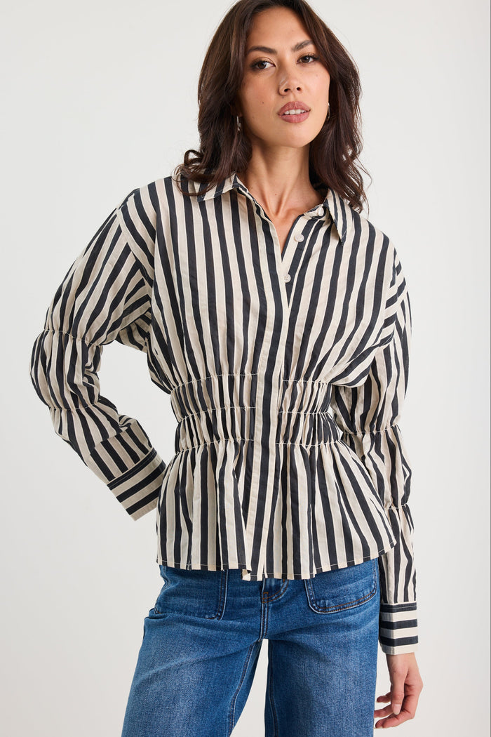 Woman wearing a black and white striped shirt with blue jeans on a white background
col_pattern
