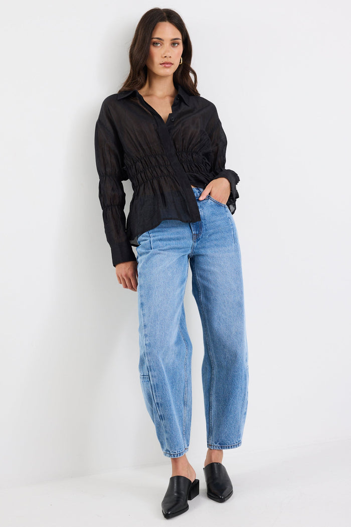 Woman wearing a black shirt and blue jeans on a white background