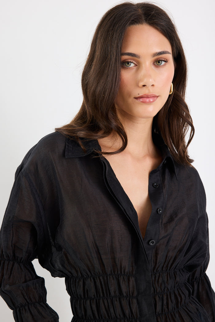 Woman wearing a black blouse against a white background