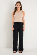 Woman wearing a beige tank top and black pants on a white background
col_pattern