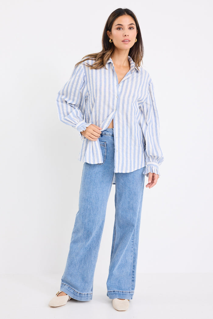 model wears a blue and white stripe shirt and blue jeans