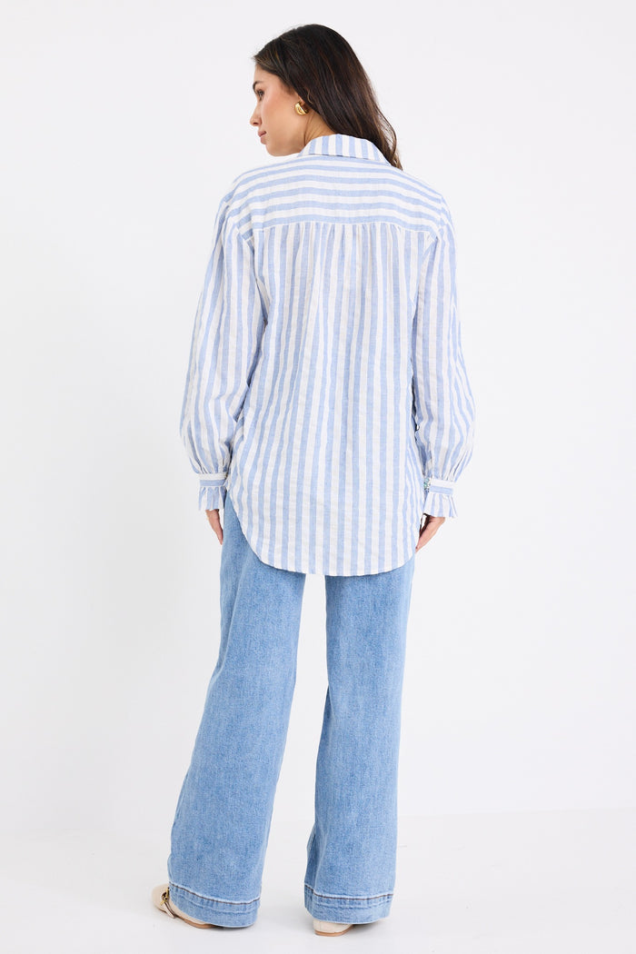 model wears a blue and white stripe shirt and blue jeans