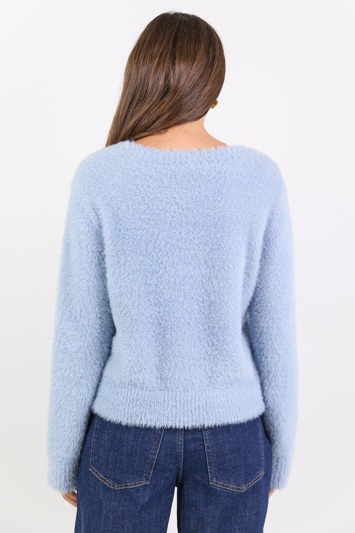 Person wearing a light blue sweater and dark blue jeans on a white background
col_pattern