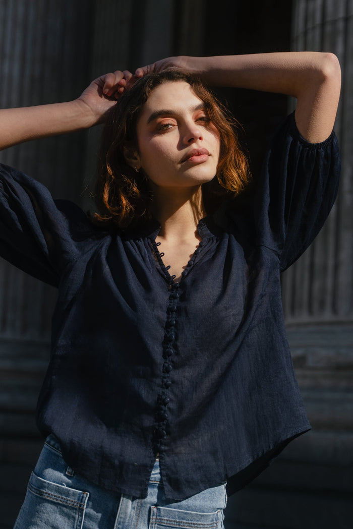 Woman posing with hands behind head against classical architecture