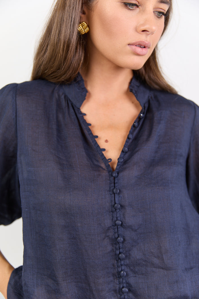 Woman wearing a navy blue shirt with a white background