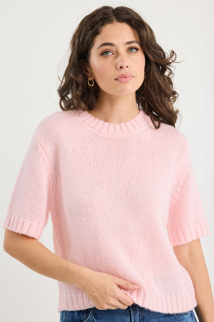 Woman wearing a pink sweater and blue jeans against a white background
col_pattern